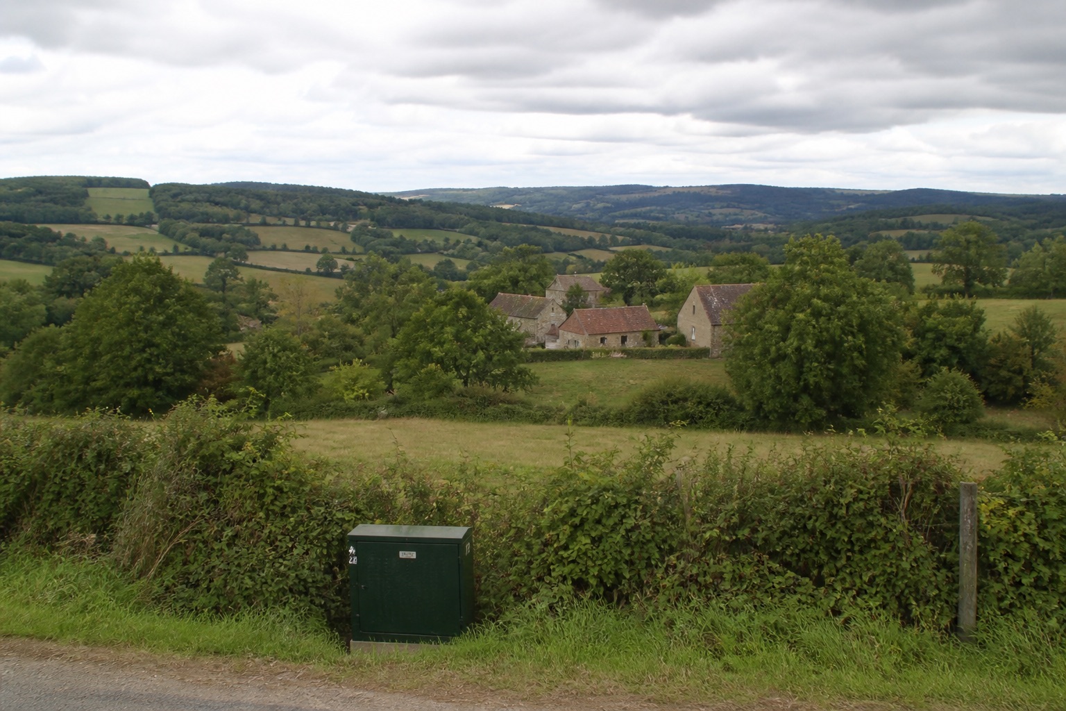 Hameau et campagne de Creuse, sous un ciel d’été couvert.